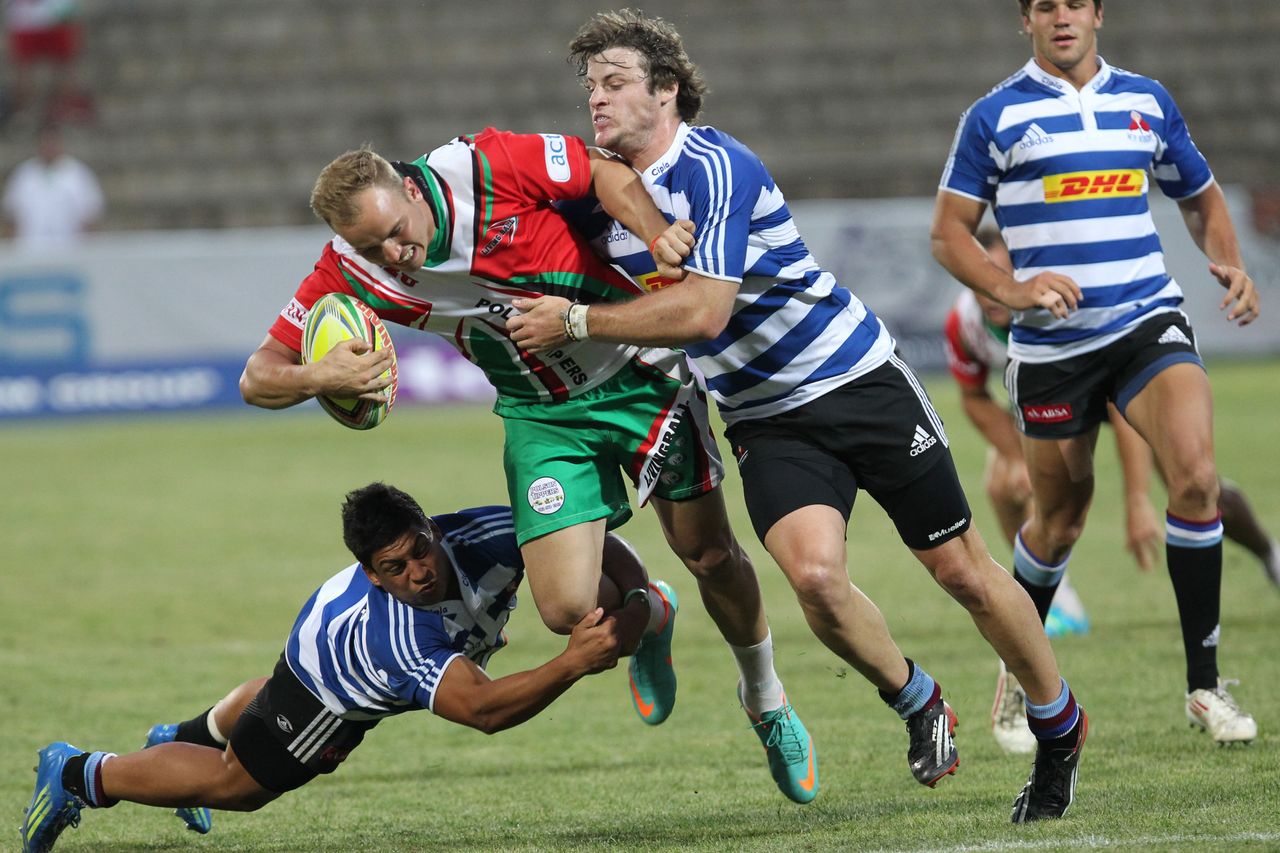 A player carrying the ball through a tackle